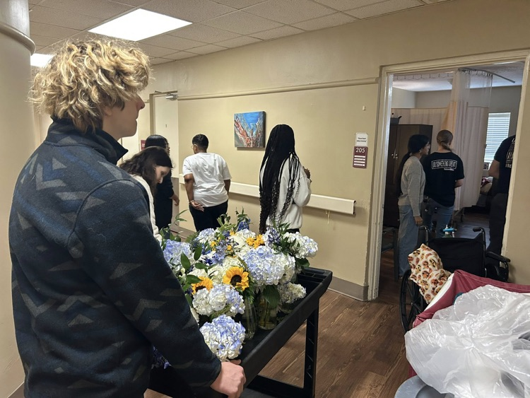 McAdory High School students hand out flowers out to residents in a retirement community.