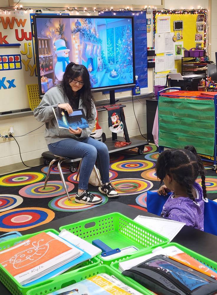 A Center Point High School student reads a book to a Center Point Elementary student.