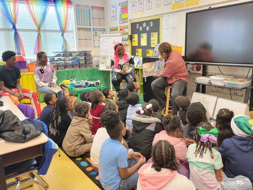 Center Point High School students read to Center Point Elementary students while sitting inside a classroom.