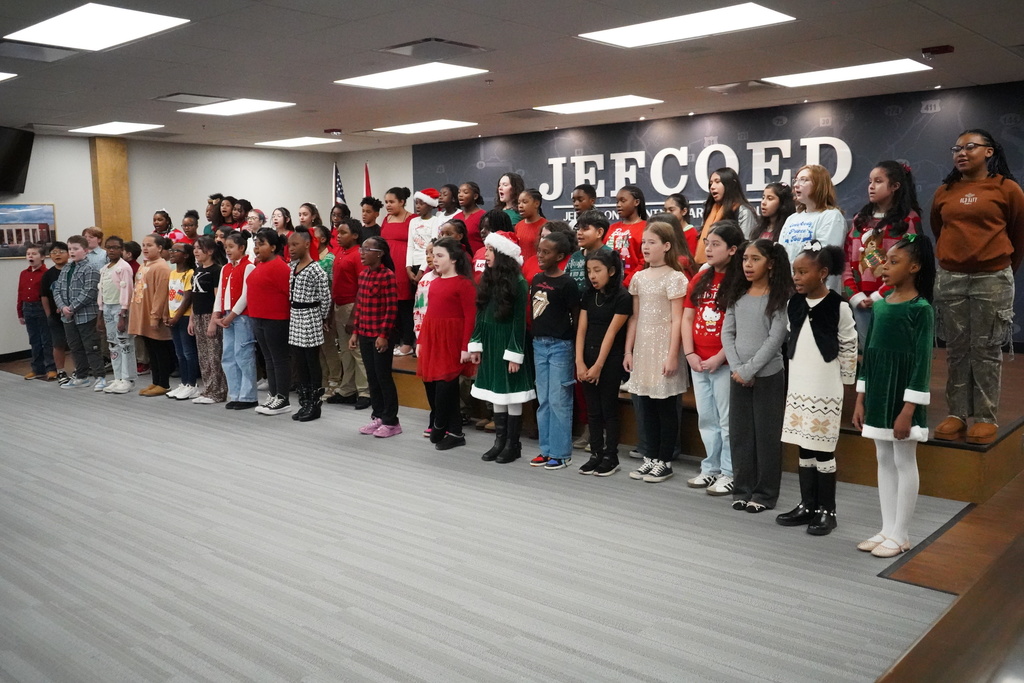 Choirs from Grantswood Community School and Irondale Community School perform a song in the Jefferson County Schools Board of Education board room.
