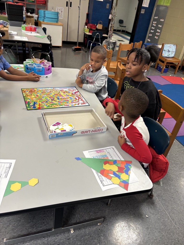 Students sit in a classroom and play a game of Candyland.
