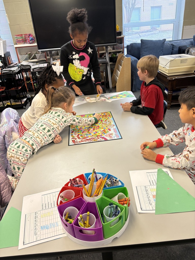 Students sit at a table in a classroom and play a game of candyland.