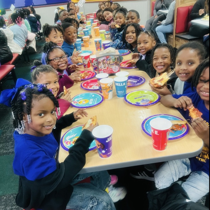 Students eating pizza at Chuck E. Cheese.