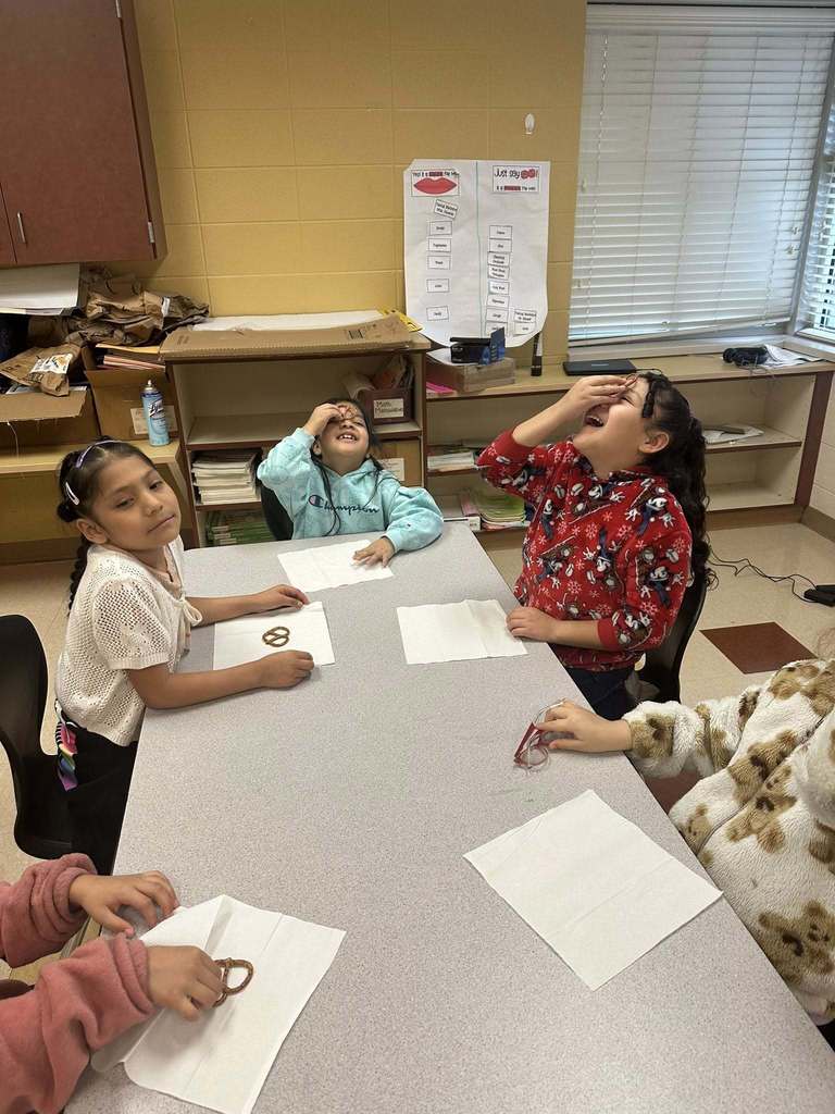 Students balancing a pretzel on their noses