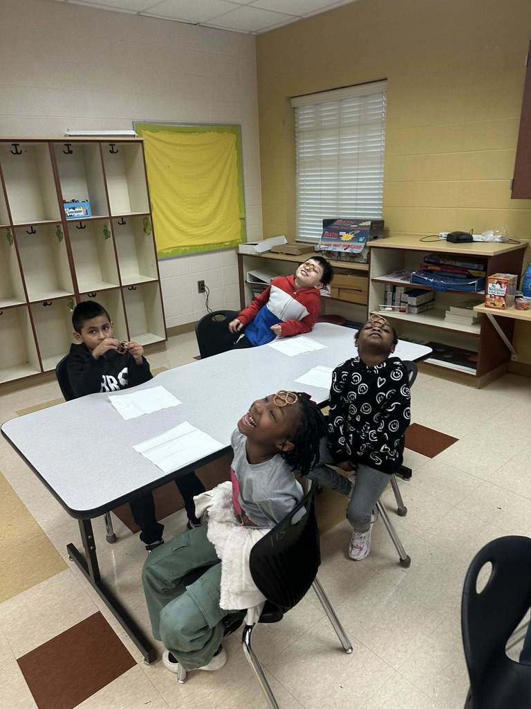 Students balancing a pretzel on their noses