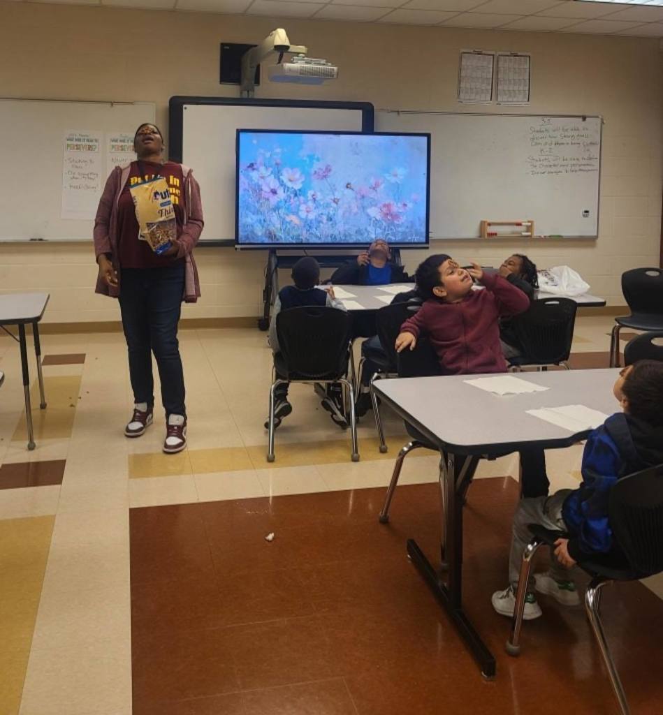 Teacher balancing a pretzel on her nose