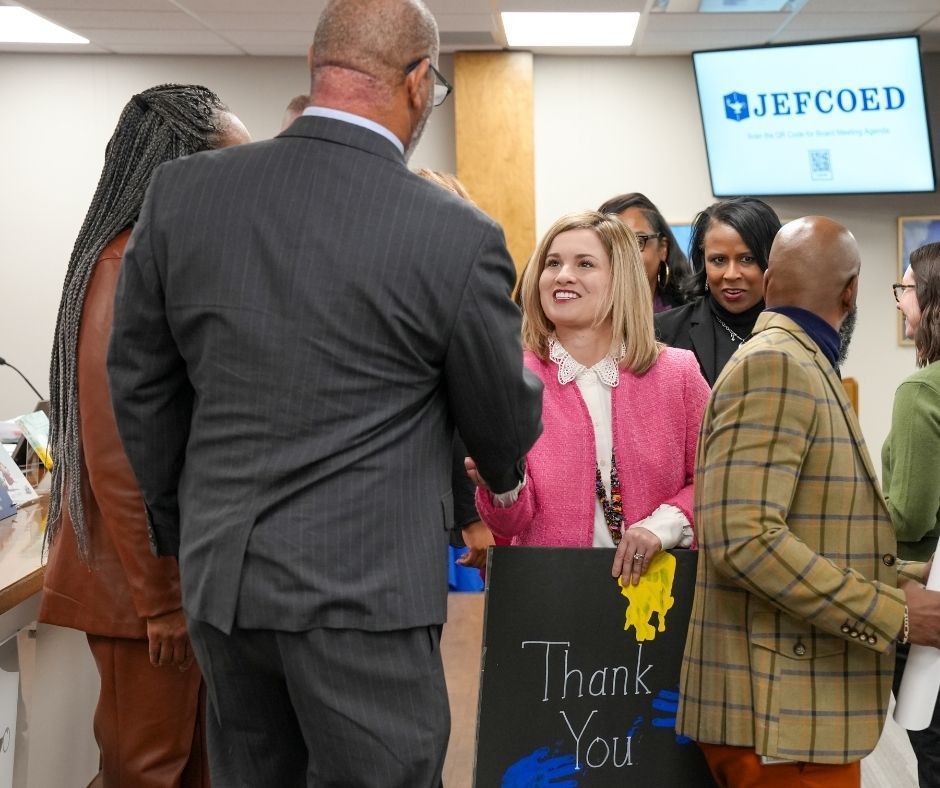 Fultondale Elementary school's principal shakes Mr. Walter Curry's hand while holding a large thank you note.