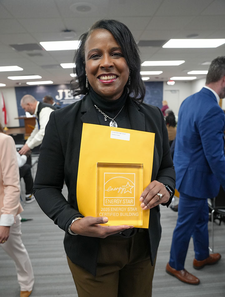Gardendale High School's principal holds an Energy Star award and smiles for a photo.