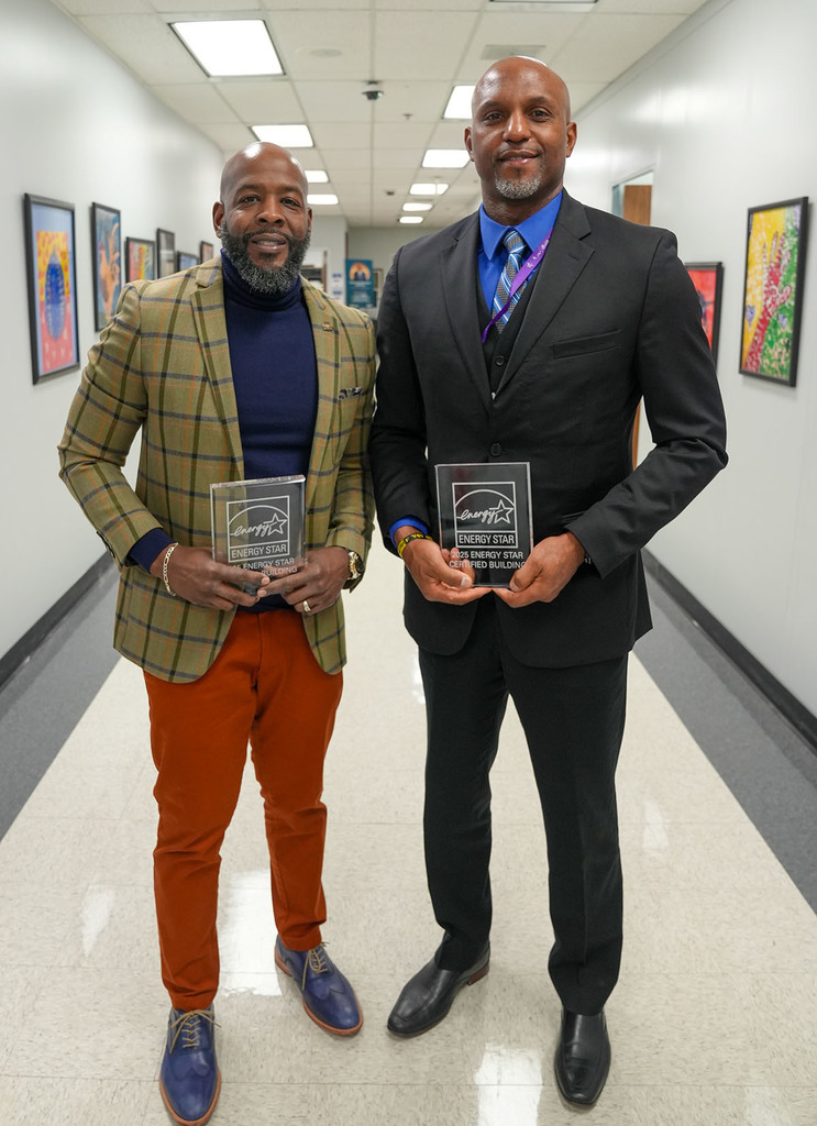 Two JEFCOED principals pose for a photo with Energy Star awards in their hands while standing in the hallway of the board of education.