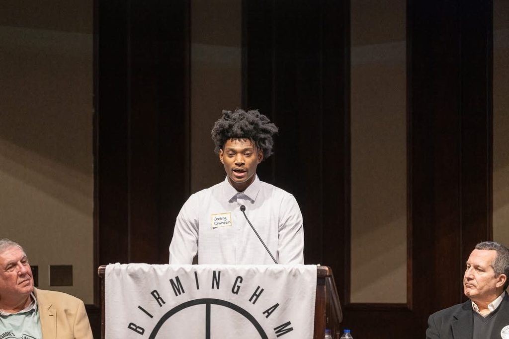 Shades Valley High School student Jeremy Chatman speaks into a microphone at the Birmingham Tip Off Club meeting.