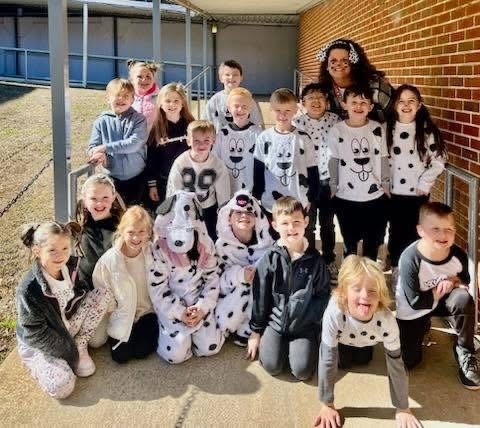 Students and a teacher at Bagley Elementary School dress like dogs from 101 Dalmations and pose for a photo outside the school.