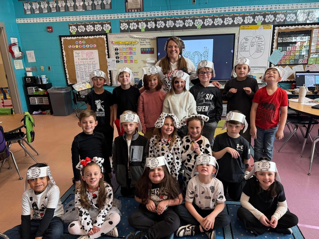Students and a teacher at Bagley Elementary School dress like dogs from 101 Dalmations and pose for a photo in a classroom.