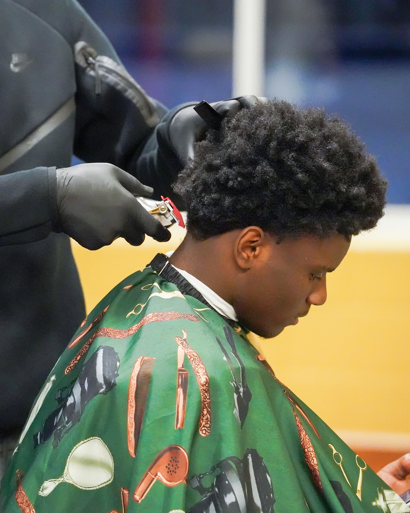 A young man receives a haircut. Close view of clippers. 