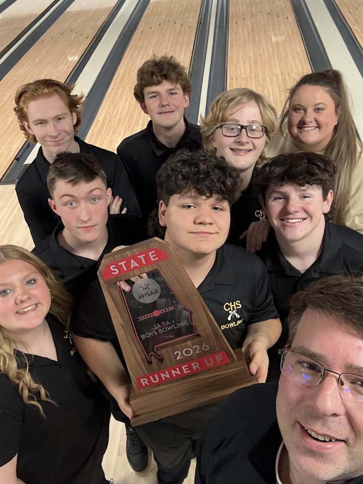 Corner High School's bowling team poses for a photo at the bowling alley while holding their 2026 State Runner Up trophy.