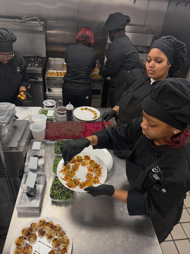 Clay-Chalkville FCCLA students wear chef uniforms and prepare food inside a kitchen.
