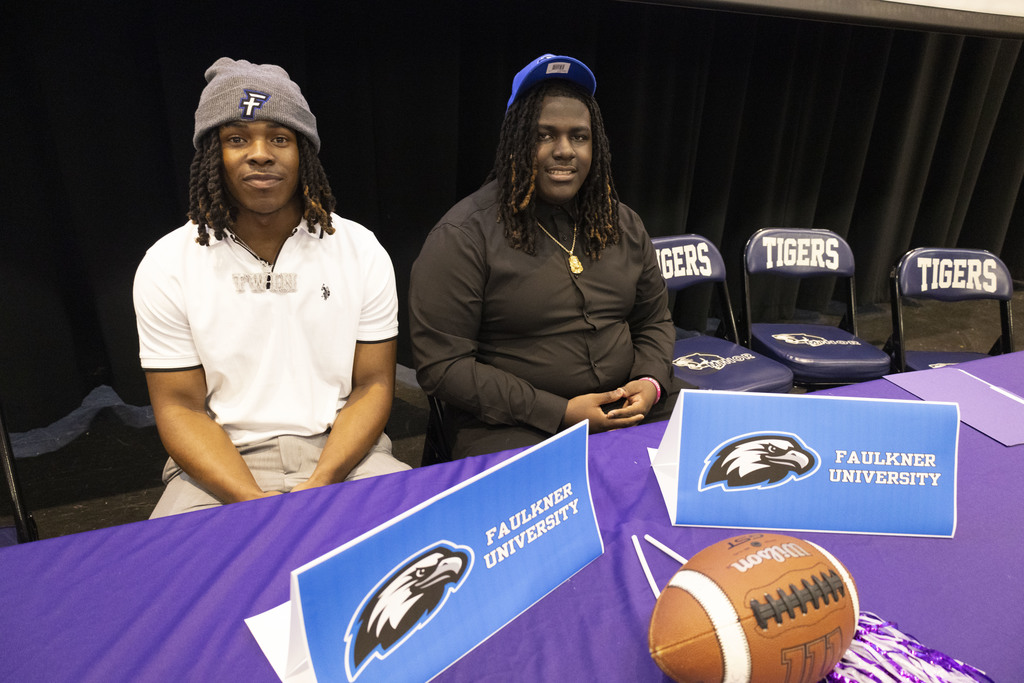 TreVone Hurth and Jaylen Ivy sit at a table and smile for a photo during Minor High School's National Signing Day Ceremony.