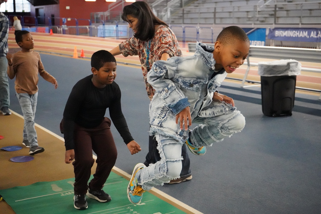 Two students participate in a long jump event at the Elementary ExEd Track and Field day at the Birmingham Crossplex.
