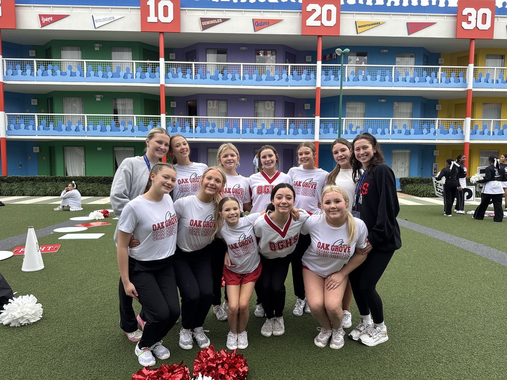 Oak Grove High School Jr. High cheerleaders stand together for a photo with their coaches. Some cheerleaders are wearing matching T-shirts that say Oak Grove Cheer, while others wear jerseys that say OGHS.