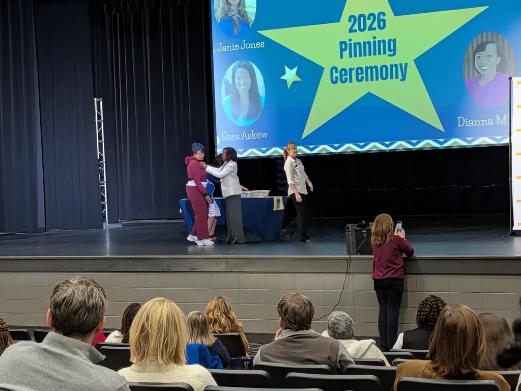 Samantha Bonner receives a pin on a stage to honor her achieving National Board Certification.