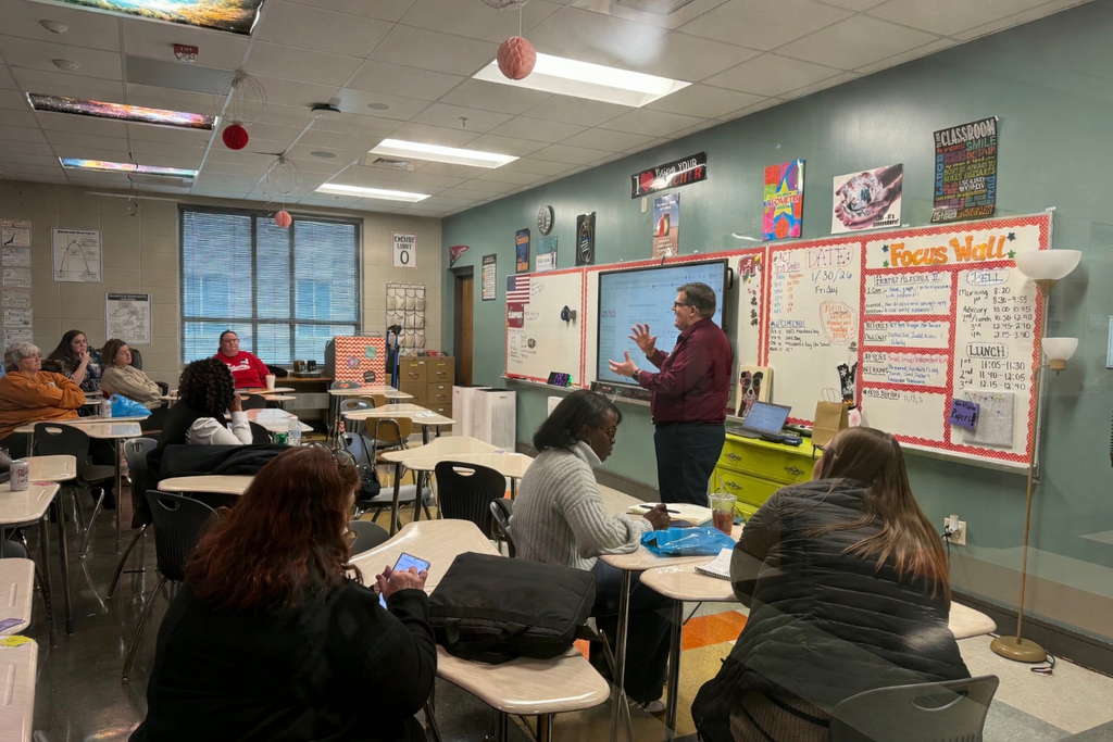 Mr. Paul Kelsey leads a presentation inside a classroom.