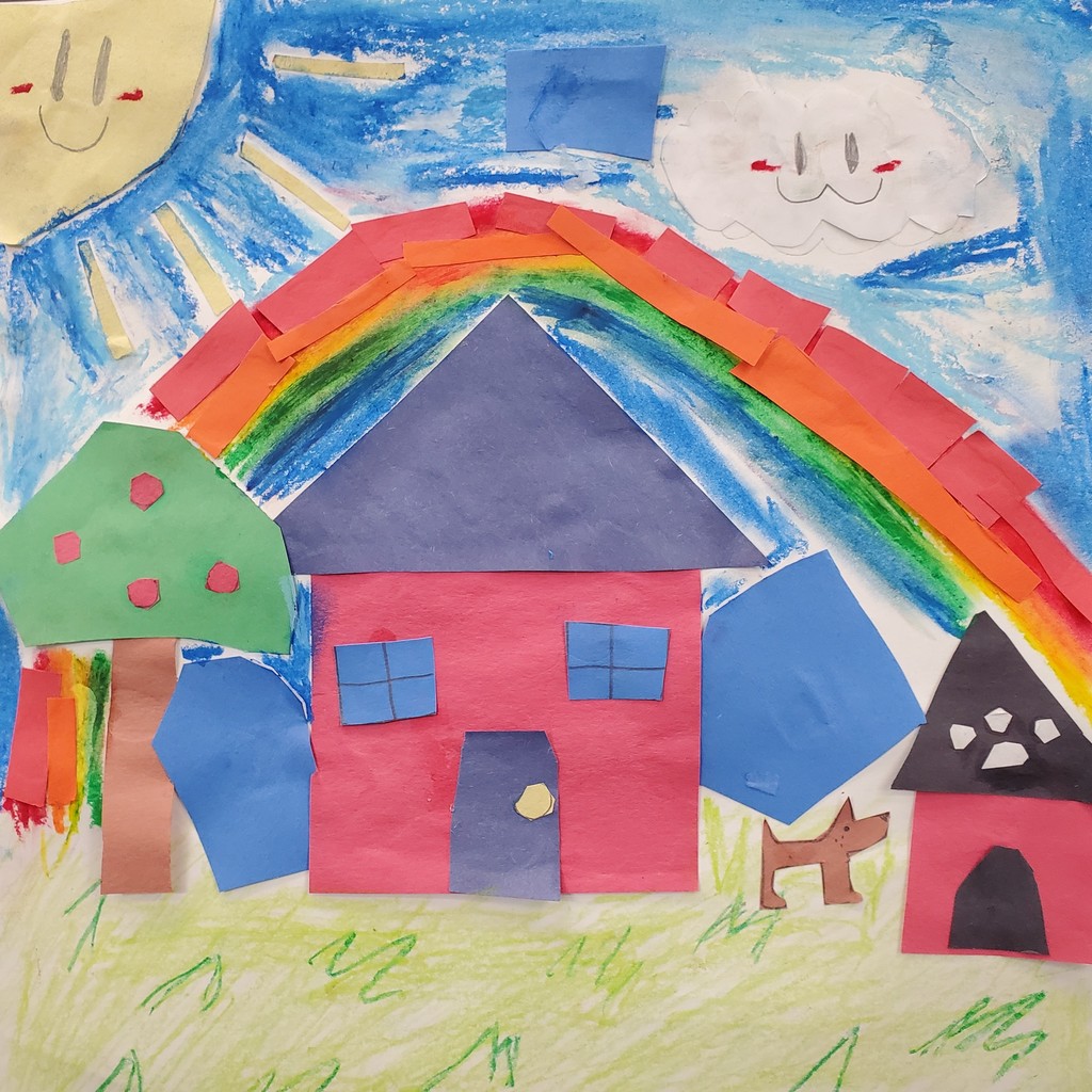 Hand-made art project depicts a house next to an apple tree and a doghouse with a dog nearby. There is a rainbow over the house and a blue sky with a cloud and sun that both have smiley faces on them. The art was made using paper and oil pastels.