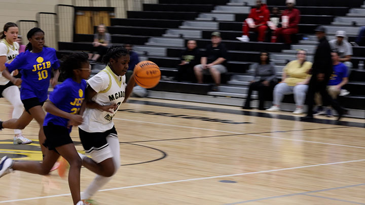 A McAdory Middle School girls basketball player dribbles a ball down a court during a game against JCIB's middle school team.
