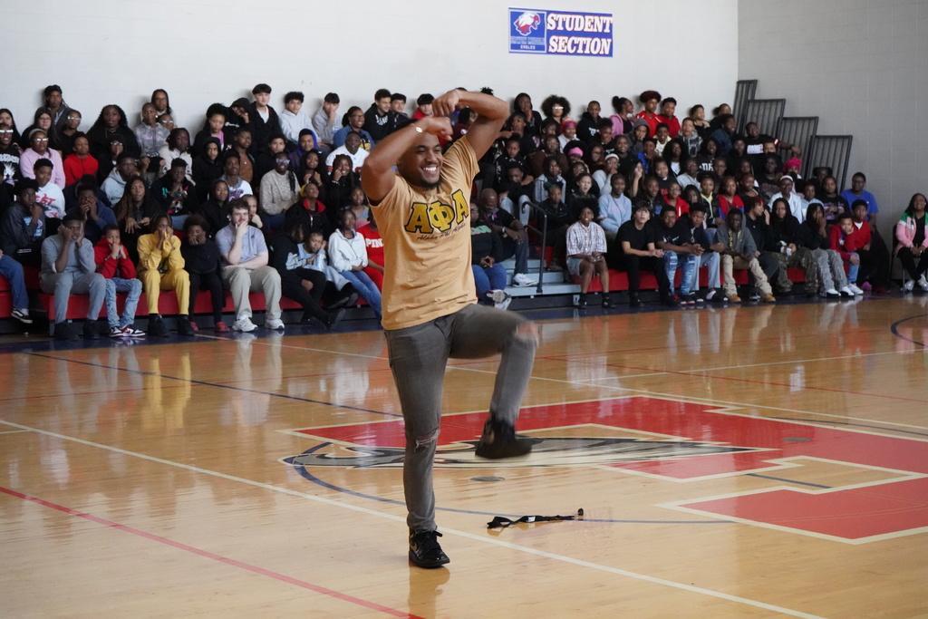 A man performs a routine in front of students in Erwin Middle School's gym.