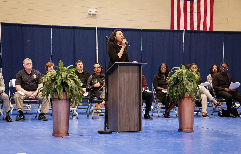 Dr. Makella Moore Harris speaks into a microphone during Fultondale High School's Black History Month Program.