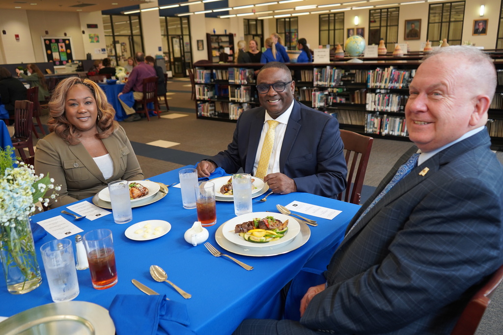 JEFCOED Superintendent Dr. Walter and board members sit at a table inside Mortimer Jordan's library and smile for a photo.