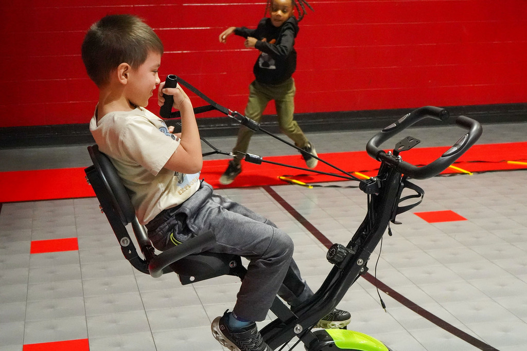 A Lipscomb Elementary School student does an arm exercise while sitting on a stationary bike.