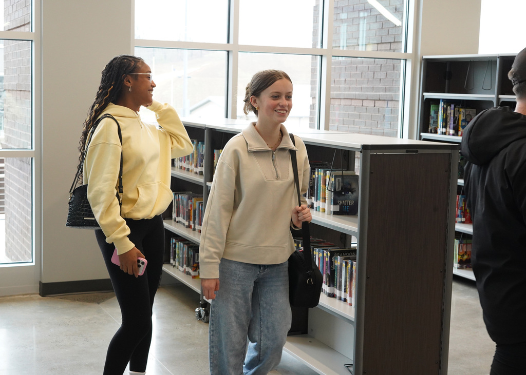 JCIB students walk through the new school's library.