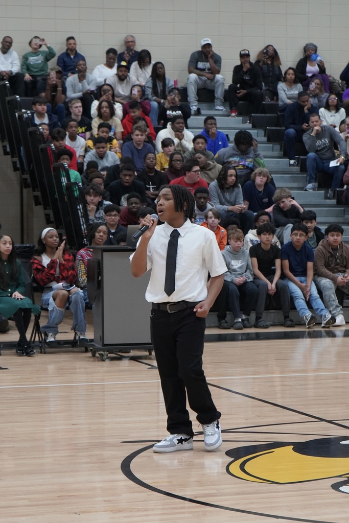 A student sings into a microphone inside McAdory Middle School's gym during the school's Black History Month program.