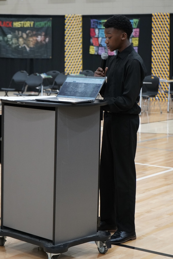 A student speaks into a microphone during McAdory Middle School's Black History Month program.