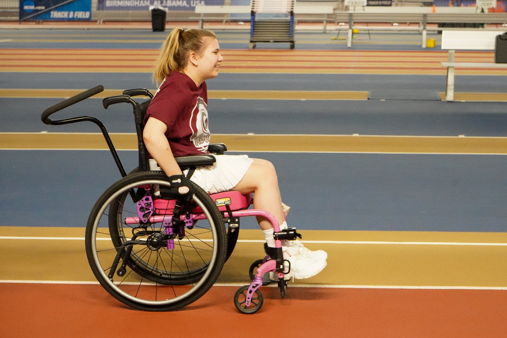 A student wheels her wheelchair down the track at the Birmingham Crossplex during a race.