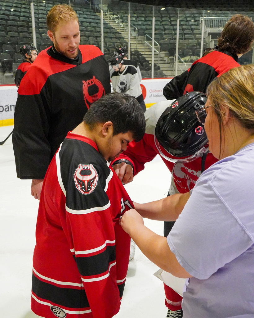 A student gets his Birmingham Bulls jersey signed by a hockey player.