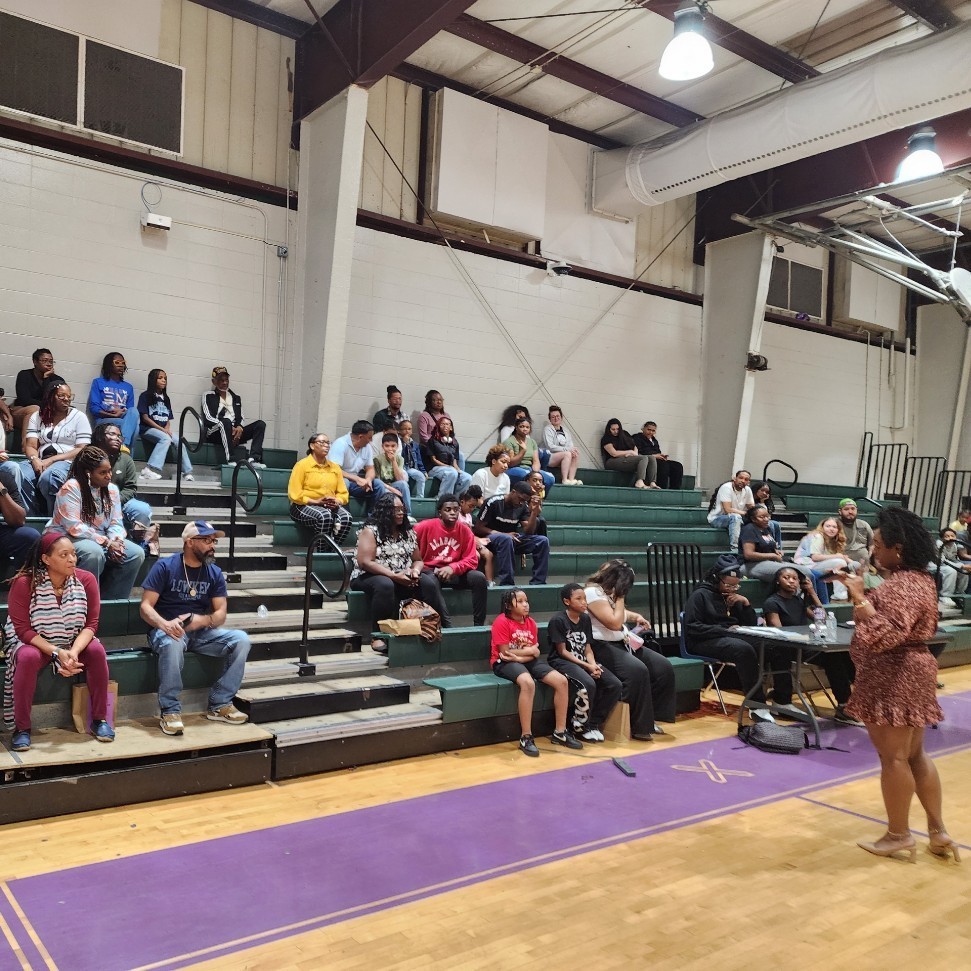 Ms. Smith welcoming parents and students and discussing the efforts to encourage better attendance in the Minor Middle gym on Parent Night.
