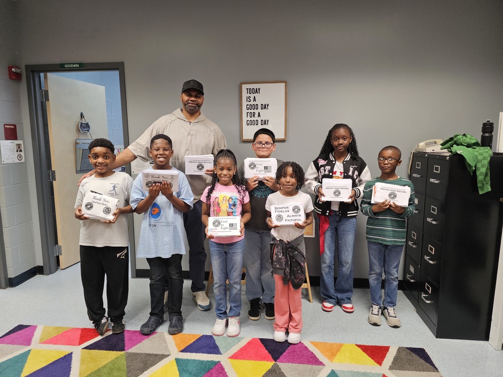 Mr. Howard with 7 students holding over 700 letters being sent to marines.