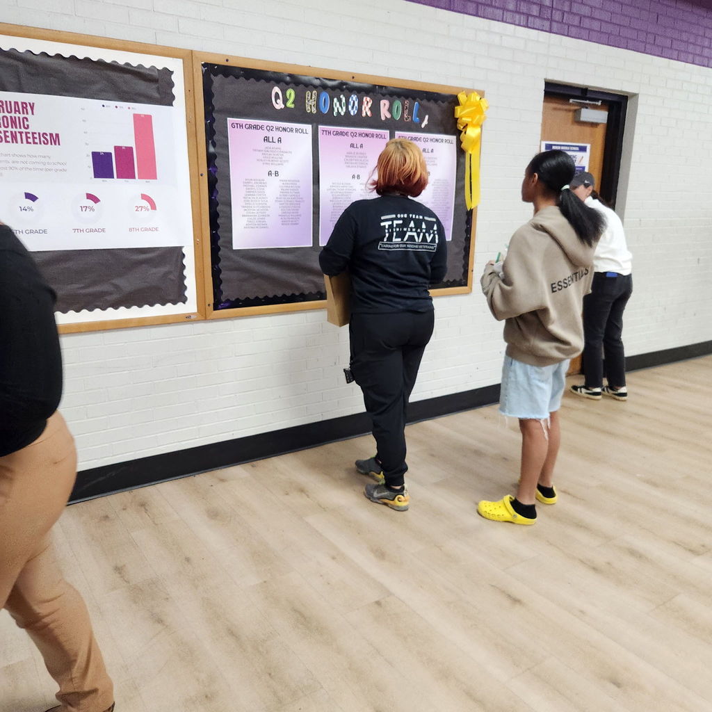 A parent and student reading over the honor roll list posted in Minor Middle's Commons on Parent Night.