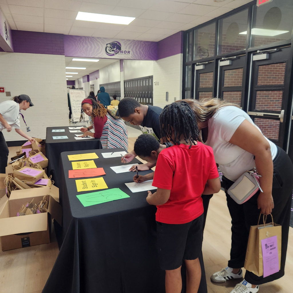 Families attending the Parent Night at Minor Middle. When parents signed in, they were given a goodie bag. Parents were able to use the bag to collect the bags of take-home activities.