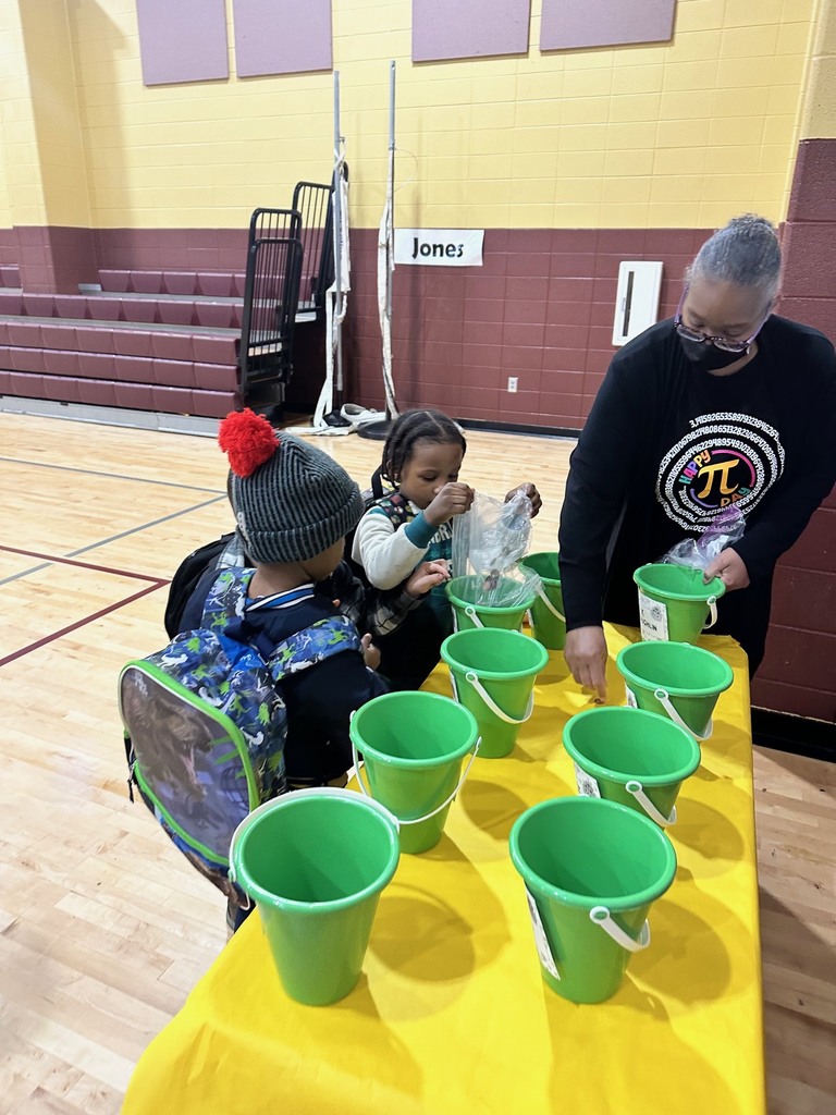 a teacher and students putting coins into a green bucket that will go towards raising fund for peer helpers