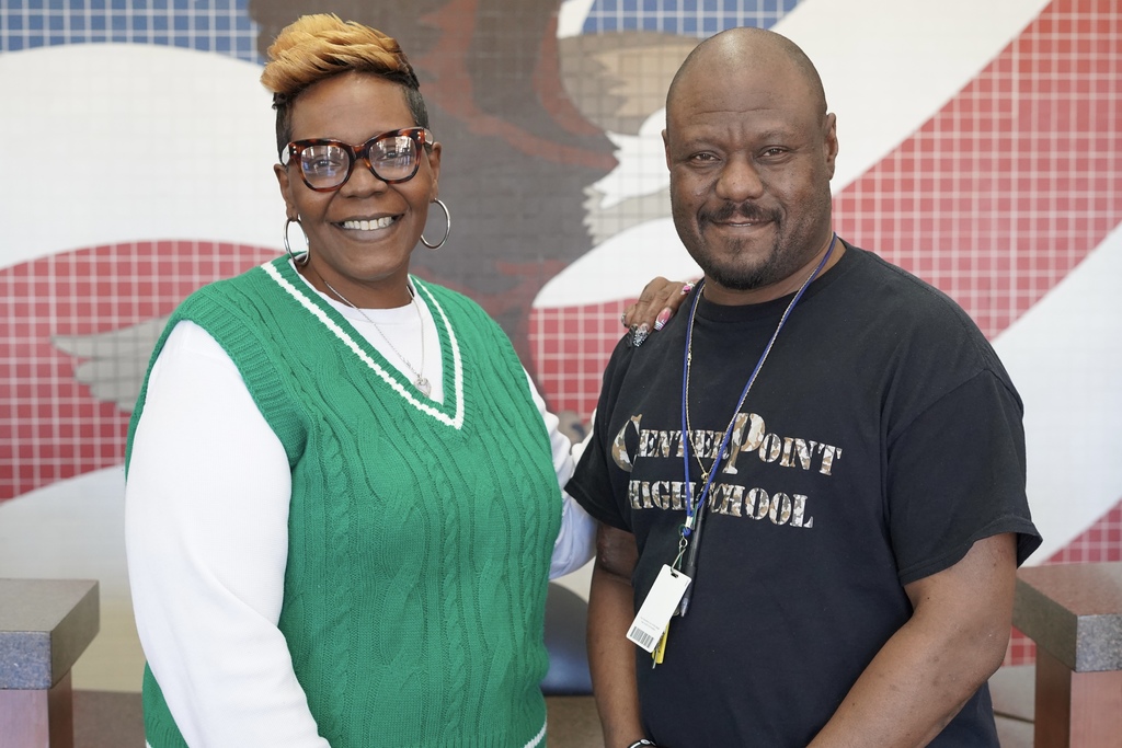Center Point High School teachers Ms. Anderson and Mr. Pope stand together for a photo in front of a mural of an eagle.
