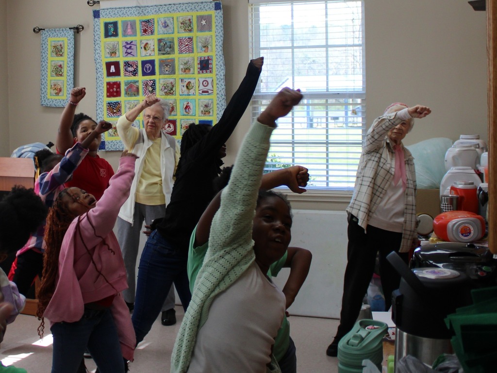 A group of girls and women participate in an exercise class.