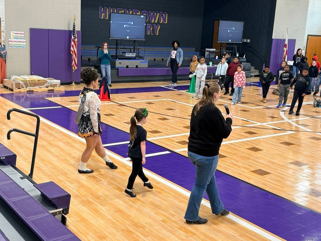 Two girls and an adult teach Irish dancing to a group of students in the Hueytown Primary School gym.