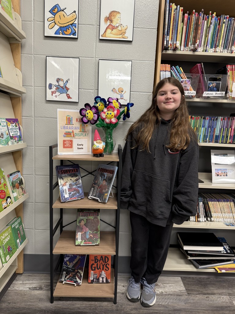 kid Librarian picture for the month of March. Student featured in front of a book display