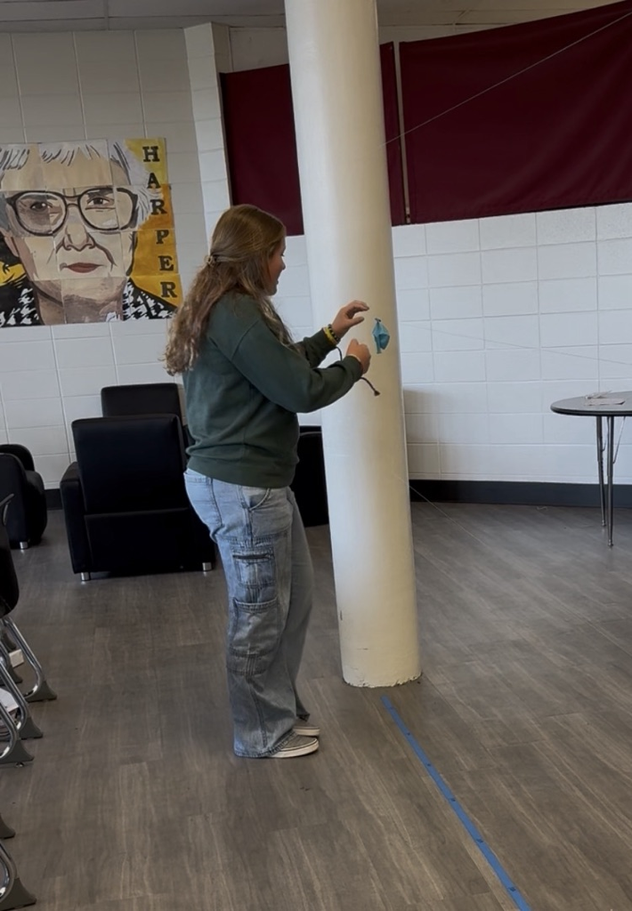student catching balloon rocket on string 