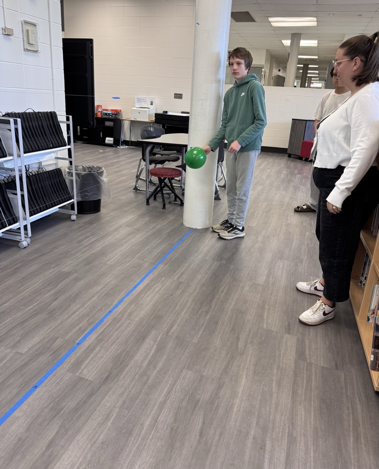 student sending a balloon rocket down a string to measure velocity