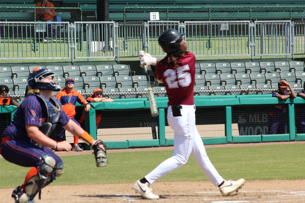 A Shades Valley High School baseball player with the number 25 on his jersey swings a bat during the 4th Annual Rickwood Classic at Historic Rickwood Field in Birmingham, AL. The catcher from Fultondale High School looks up in to the air to track the ball. 
