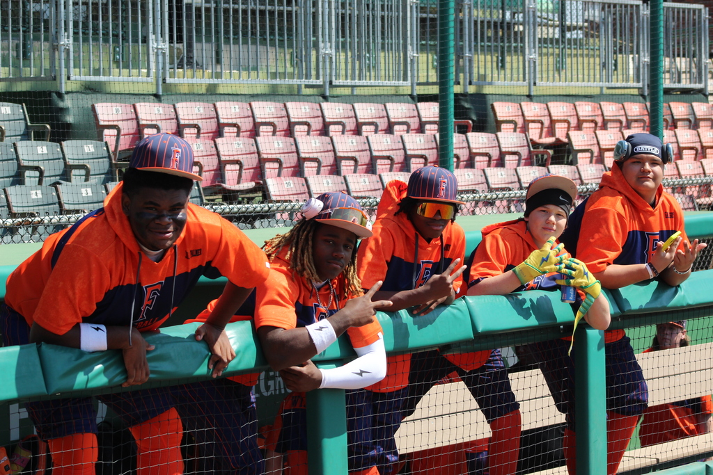 Five players from the Fultondale High School baseball team hand over the fence and make hand signals at the camera during the 4th Annual Rickwood Classic at Historic Rickwood Field in Birmingham, AL.