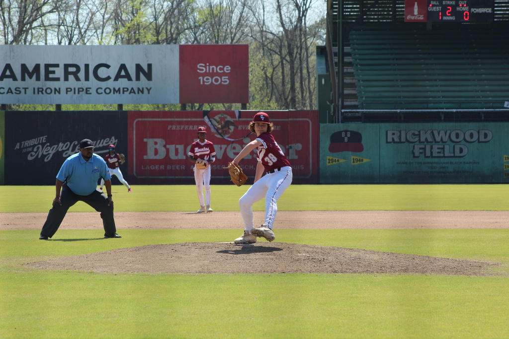 A Shades Valley High School baseball pitcher winds up for a throw during the 4th Annual Rickwood Classic at Historic Rickwood Field in Birmingham, AL. In the background you can see historical advertisements lining the walls of the field. 