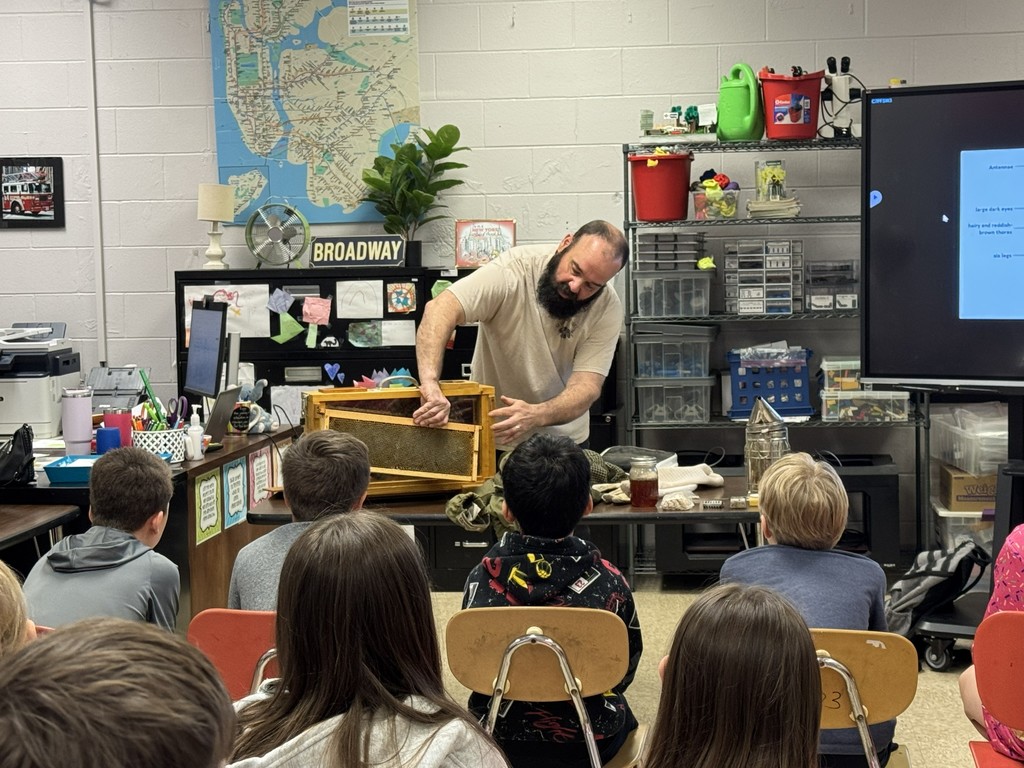 Visiting beekeeper is demonstrating how an observation hive operates. He is removing the front piece of the hive.